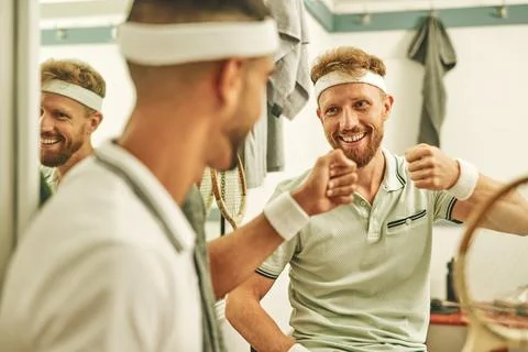 Squash bros are best bros. two young men fist bumping in the locker room after a Stock Photos