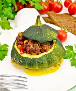 Squash green stuffed with meat on light board Foto stock