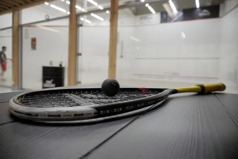 Squash racket with ball close up, laying on the table, preparing for game. co Stock Photos