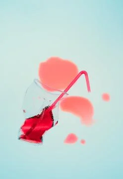 Squashed plastic cup and drink straw over blue background Foto stock