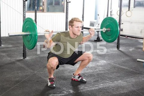 Squat workout at fitness gym center Stock Photos