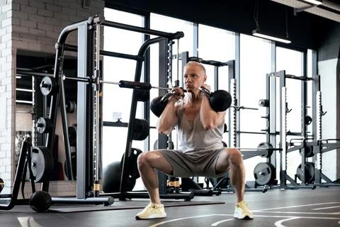 Squats with kettlebells exercise. Middle aged athlete doing functional workou Foto stock