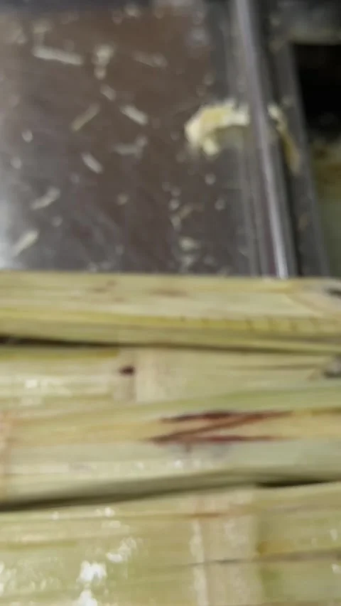 Squeeze a drink from sugar cane. produce sweet rum drink. Street vendor chop up Stock Footage 313528310