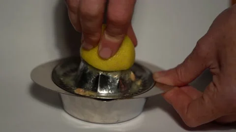 Squeeze the juice from a lemon in front of a white background, SloMo, 4k. Video stock 140922966
