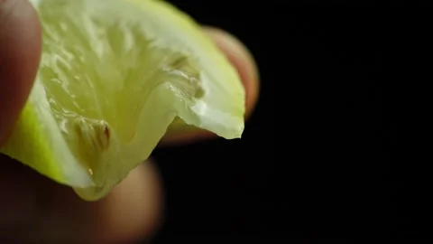 Squeeze juice from lemon, hand squeezes half yellow lemon. close-up. Stock Footage 236607473