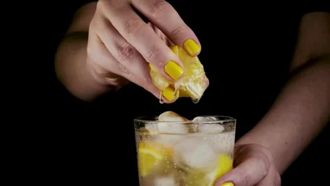 Squeeze the juice out of the half lemon by hand. Lemon juice drains from th.. Stock Footage 265838481