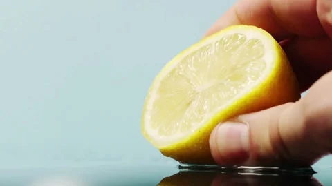 Squeeze the juice out of the half lemon by hand. Lemon juice drains from th.. Stock Footage 265838845