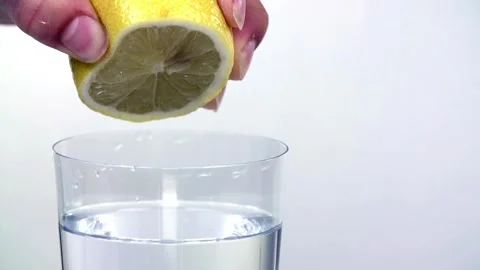 Squeeze the juice out of the half lemon by hand. Lemon juice drains from th.. Stock Footage 265839182