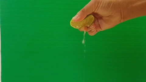 Squeeze lemon with video Slow motion on green background, Stock Footage 89973560