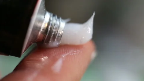 Squeeze a paste-like white opaque cream on your finger from a metal tube. Extrem Stock Footage 128996859