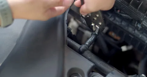 Squeeze the Spring clamp to lock the car water hose and put it back in place. Stock Footage 310912134