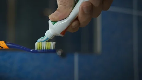 Squeeze the toothpaste onto the toothbrush. Stock Footage 120398313