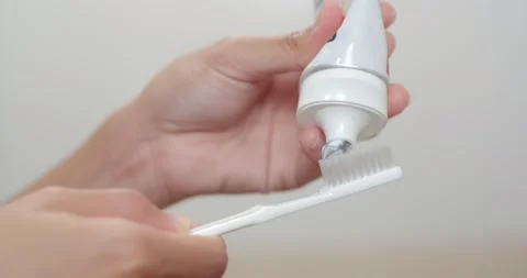 Squeeze the toothpaste onto the toothbrush. Stock Footage 236457711