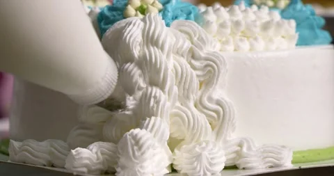 Squeeze the white whipped cream into a pattern on the cake. Stock Footage 221003682