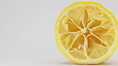 Squeezed lemon half on white background, smooth slider motion Stock Footage 341861792