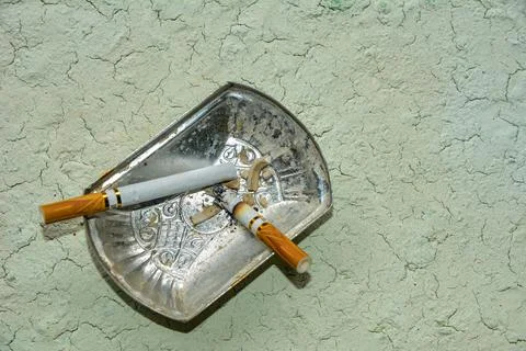 Squeezed remnants of cigarettes in an ashtray Stock Photos
