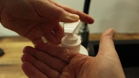 Squeezes antiseptic on his hands Stock Footage 300380602