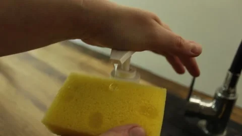 Squeezes gel onto a dishwashing sponge Stock Footage 300380596