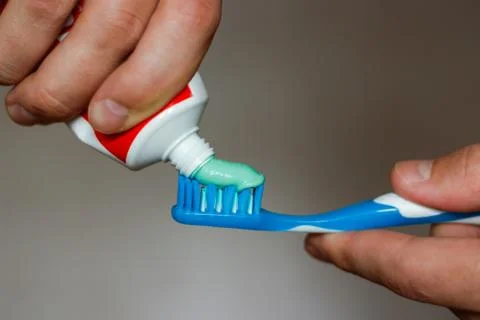 Squeezes toothpaste on the brush Stock-Fotos