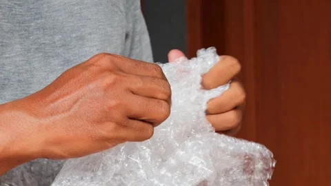 Squeezing and popping plastic bubble wrap Stock Footage 342702547