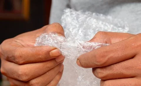 Squeezing and popping plastic bubble wrap Stock Photos