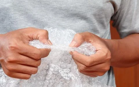 Squeezing and popping plastic bubble wrap Stock Photos