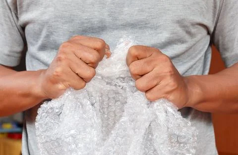 Squeezing and popping plastic bubble wrap Stock Photos