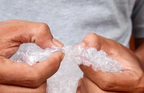 Squeezing and popping plastic bubble wrap Stock Photos