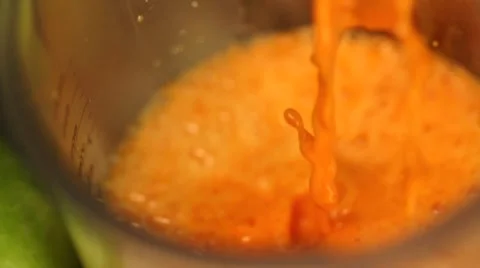 Squeezing carrot juice in slow motion Stock Footage 54559290