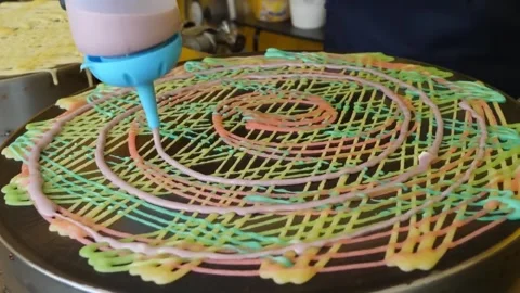 Squeezing Colorful Crepe Batter on Hot Griddle to Create Rainbow Lace Pattern 库存影片 345692498