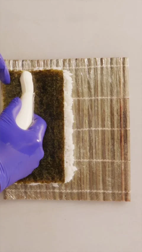 Squeezing cream cheese from piping bag onto sushi rice and nori sheet 스톡 동영상 337119206