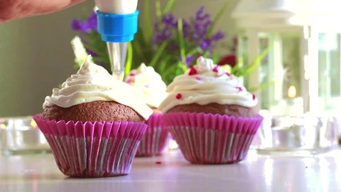 Squeezing the cream in a circle, on the muffins. Stock Footage 118711942