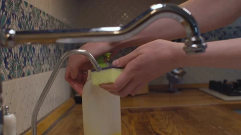 Squeezing dishwashing liquid on sponge Video stock 135379198
