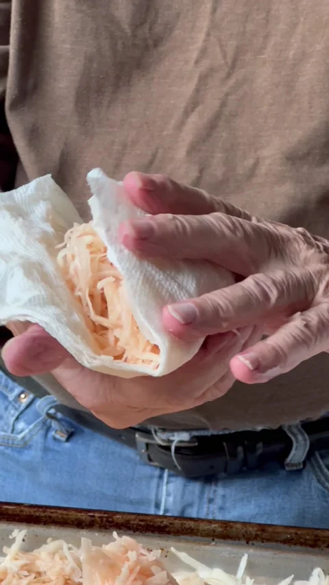 Squeezing excess moisture from grated potatoes Stock Footage 219240689