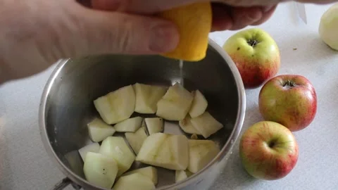 Squeezing Fresh Lemon Juice onto Apples for Jam Stock Footage 345492749