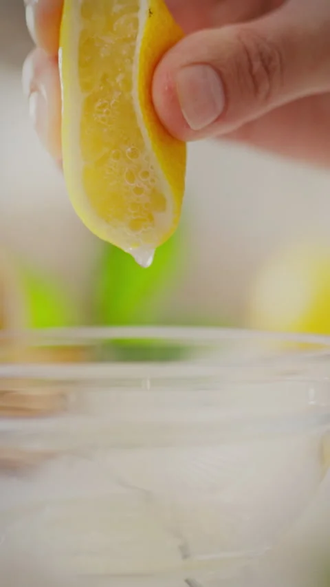Squeezing fresh lemon juice into a bowl for cooking or mixing drinks Stock Footage 331726041