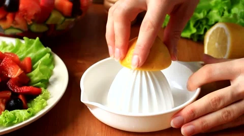 Squeezing fresh lemon juice for a salad Stock Footage 50046986