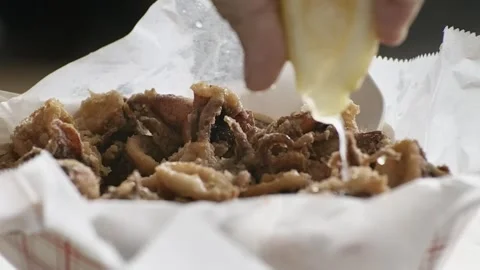 Squeezing Fresh Lemon Over Golden Fried Calamari 스톡 동영상 343361696