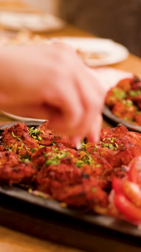 Squeezing Fresh Lemon Over Sizzling Chicken Tikka Tandoori Platter Stock Footage 344949148