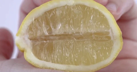 Squeezing a fresh lemon to use the ripe juice for cooking Vídeo Stock 73341365