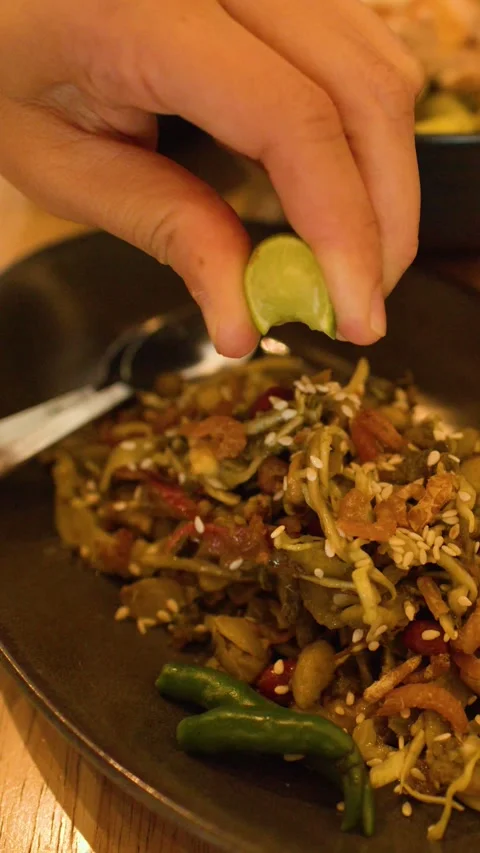 Squeezing Fresh Lime Juice Over Traditional Burmese Fermented Tea Leaf Salad Stock Footage 345710746