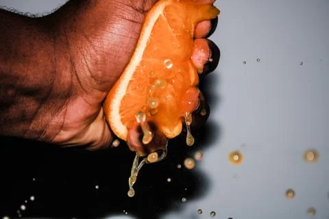 Squeezing a Fresh Orange Background Stock Photos