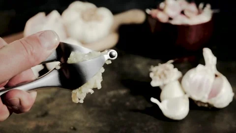Squeezing garlic with metal garlic press. Food preparing, Stock Footage 283686700