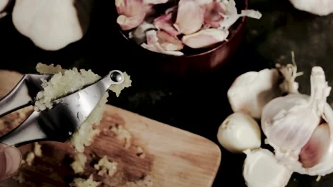 Squeezing garlic with metal garlic press. Food preparing, Stock Footage 283686701