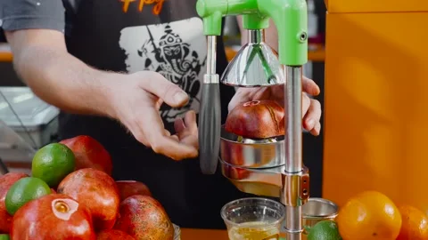 Squeezing an garnet fruit with a hand-pressed juicer. Squeezing juice garnet Stock Footage 131497910