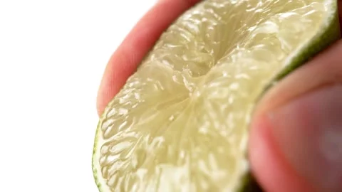 Squeezing half fresh green lime isolated on white background. Squeezing fresh Stock-Footage 336588942