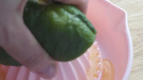 Squeezing juice from an orange with a manual citrus juicer Stock-Footage 336597516