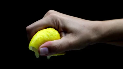 Squeezing a lemon half on black background. Citrus fruit source of vitamins.. Stock Footage 265839214