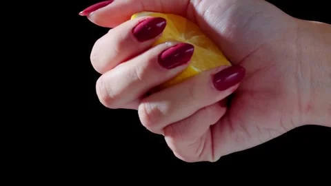 Squeezing a lemon half on black background. Citrus fruit source of vitamins and Stock-Footage 336588556