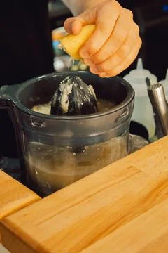 Squeezing  lemon in  home kitchen prepare fresh juice, add flavor to  dish or Foto stock